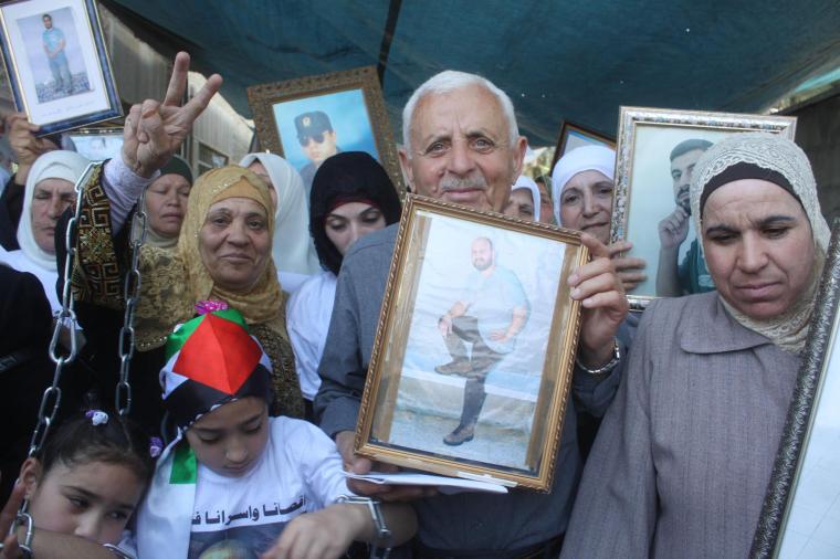 Jihad’s father, holding Jihad’s picture, celebrates his son’s upcoming release from Israeli prison. (Amjad Abu Asab)